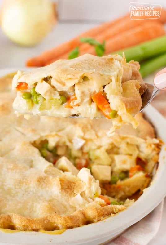 Spatula holding a slice of Easy Turkey Pot Pie over the whole Turkey Pot Pie.