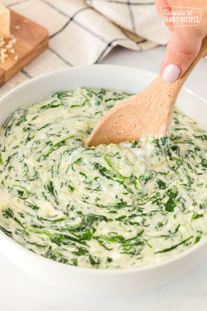 Spoon scooping into a bowl of Creamed Spinach.