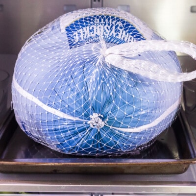 A frozen turkey thawing in a refrigerator