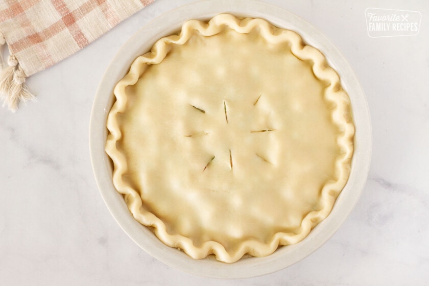 Unbaked Easy Turkey Pot Pie with a scalloped edge crust and slits in the top of the pie.