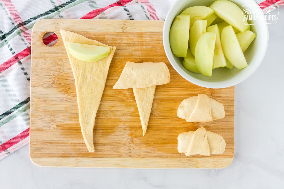 Cutting board with apples wrapping in crescent rolls for Apple Dumplings.