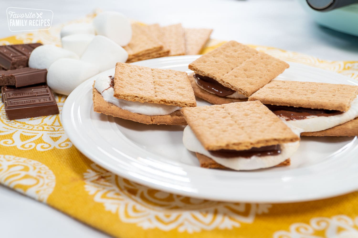 4 Smore's on a plate with an air fryer in the background