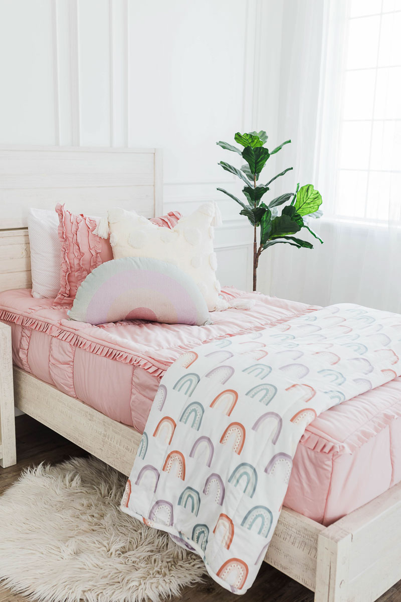 pink girls zipper bedding with a rainbow blanket and rainbow pillows