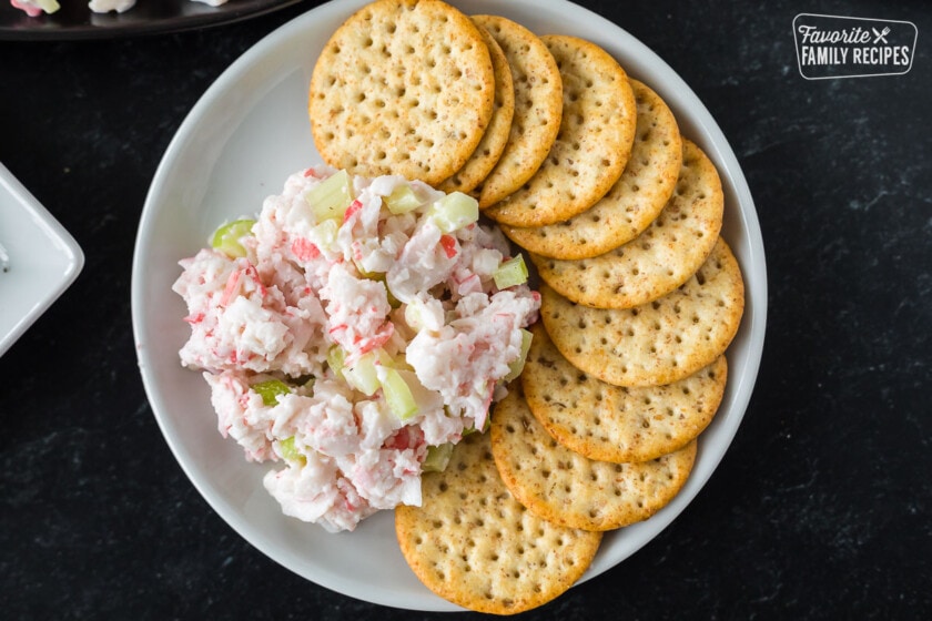 Crab salad dip on a plate with crackers.