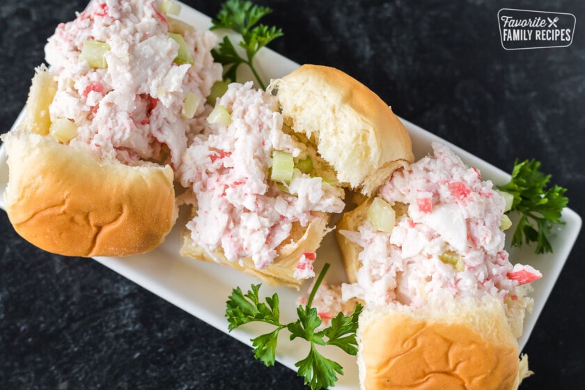 Three crab salad sandwiches on a plate.