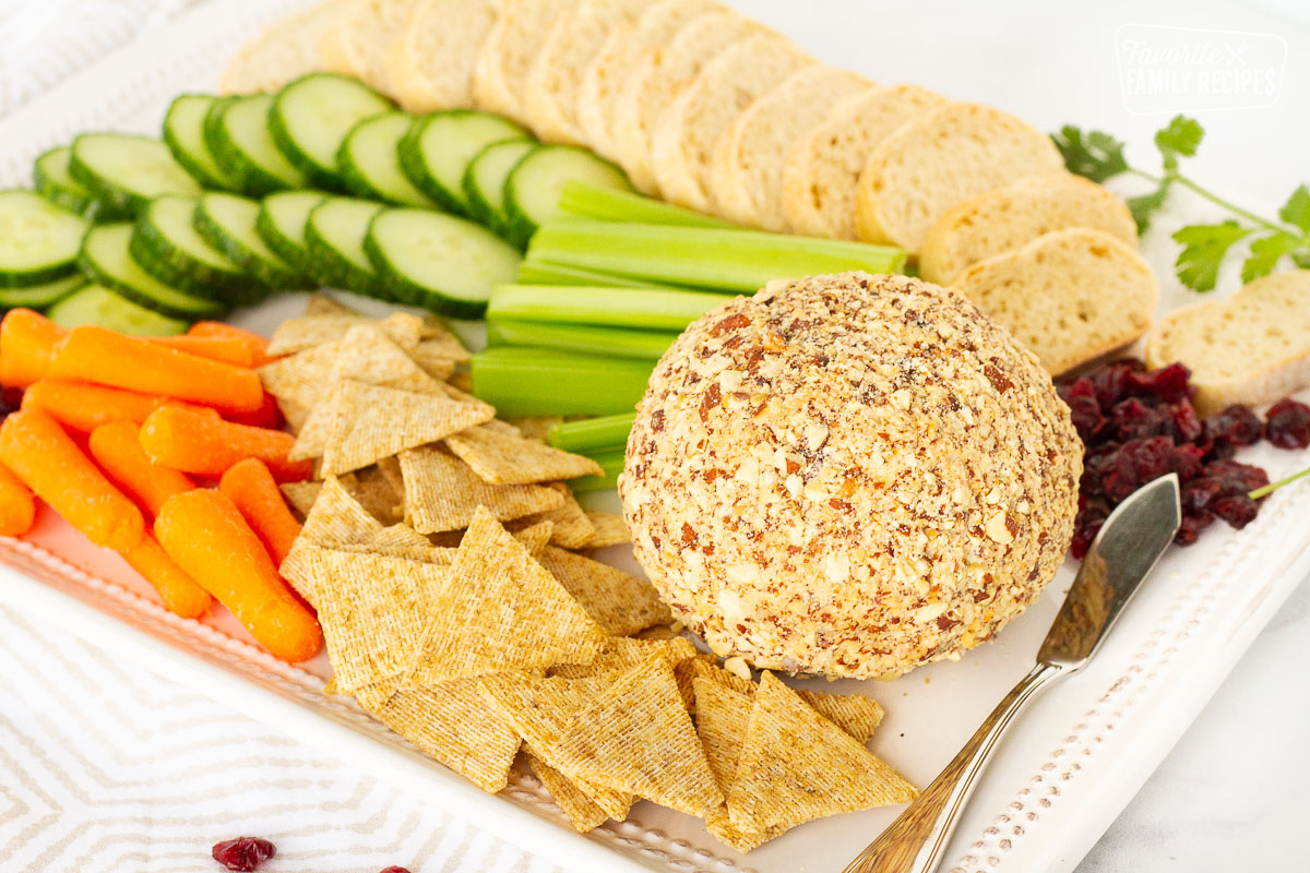 Whole Cranberry Almond Bacon Cheese Ball with vegetables, crackers and bread.