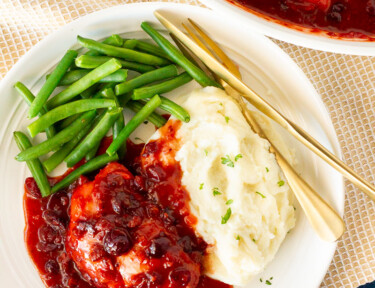 Plate of Cranberry Chicken, green beans and mashed potatoes.
