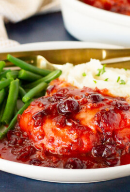 Cranberry Chicken on a dinner plate with mashed potatoes and green beans.
