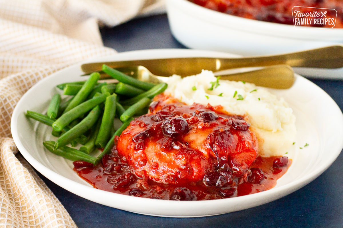 Cranberry Chicken on a dinner plate with mashed potatoes and green beans.