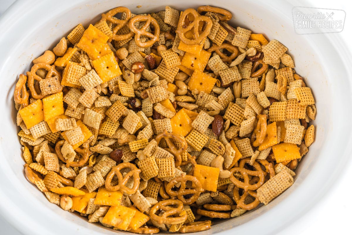 Chex Mix in a crockpot coated with sauce