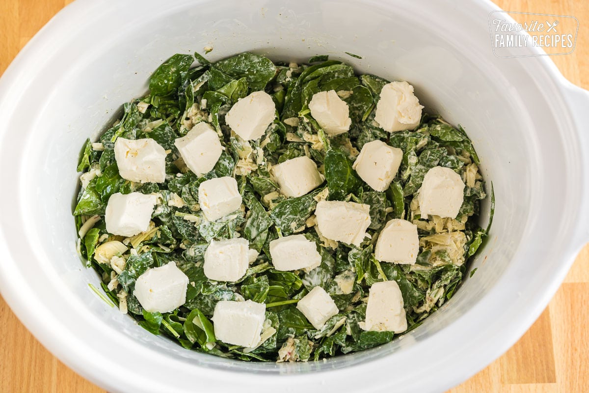 Spinach, cheese, Greek yogurt, and seasonings topped with squares of cream cheese