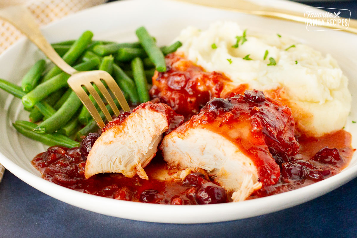 Fork holding piece of cut Cranberry Chicken.