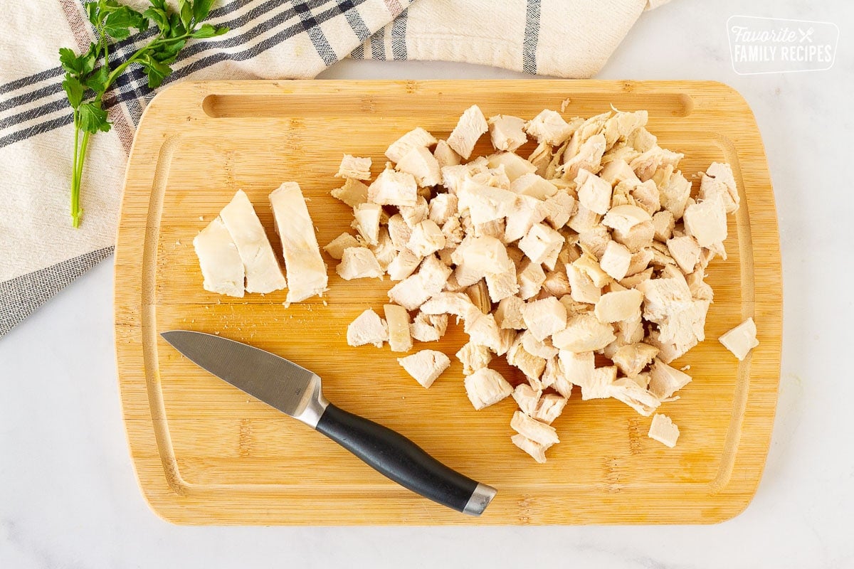 Cut up chicken on a cutting board for Homemade Chicken Noodle Soup.