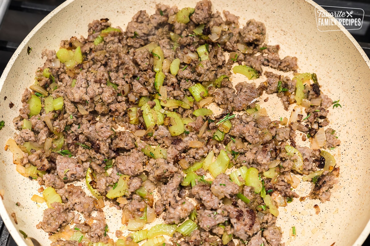 Cooked sausage, onions and celery in a skillet