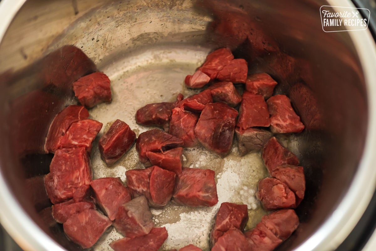 Beef pieces being seared in an Instant Pot to make goulash