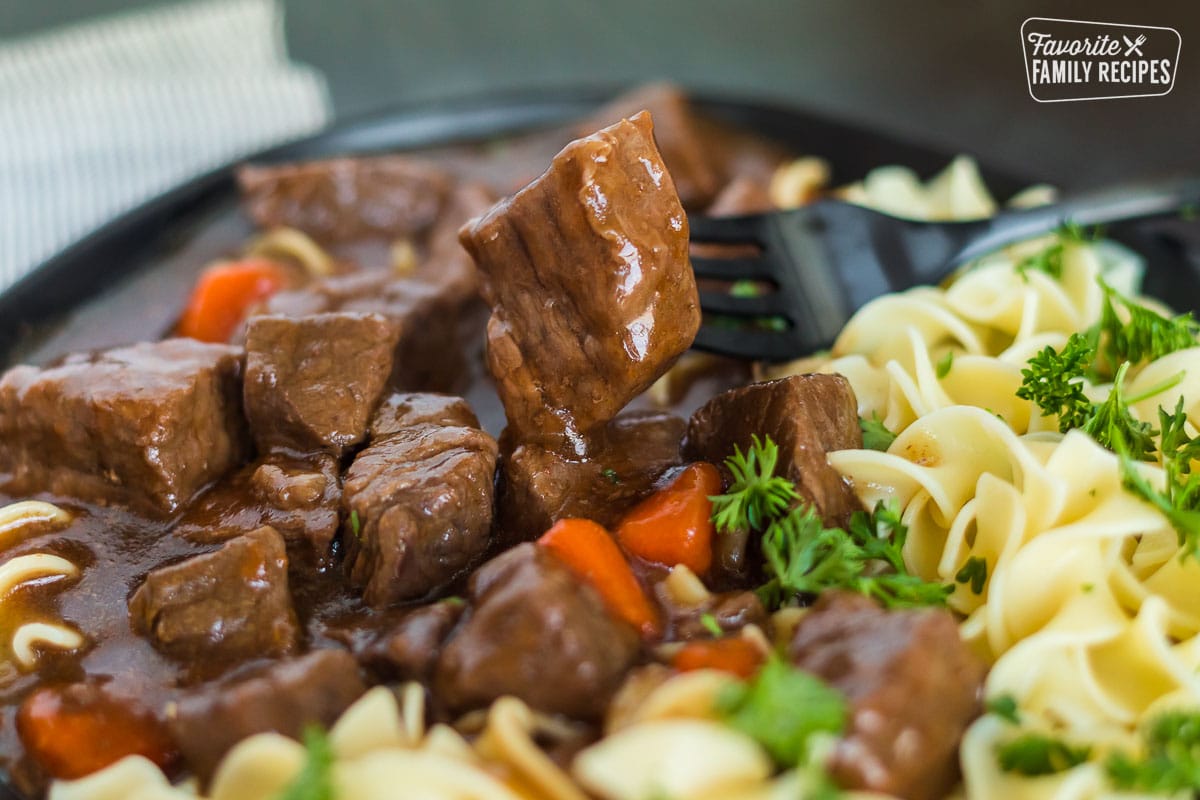 A close up of a tender piece of cooked stew meat on a plate of Instant Pot goulash