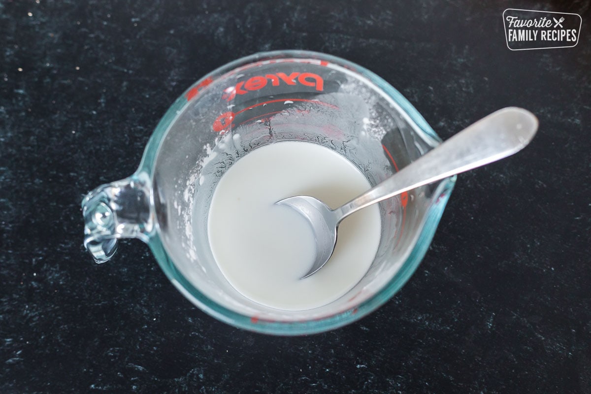 cornstarch and water mixed in a liquid measuring cup to make a slurry for thickening