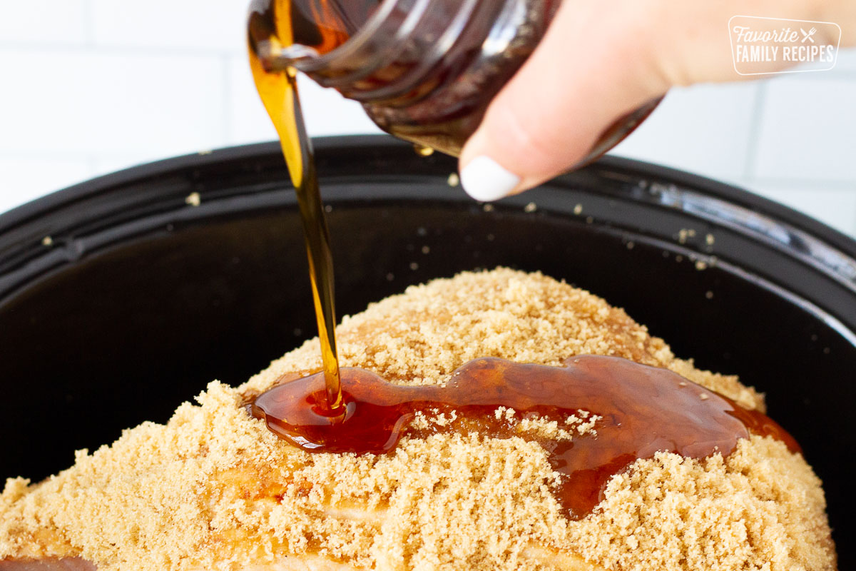 Maple syrup pouring on a Spiral Ham in the Slow Cooker.