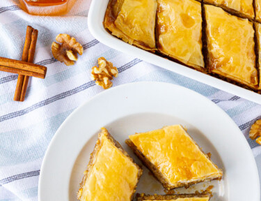 Top view of sliced Baklava on a plate and dish of Baklava.