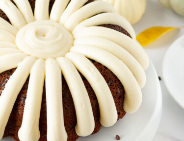 Side view of a Pumpkin Bundt Cake decorated with cream cheese frosting.