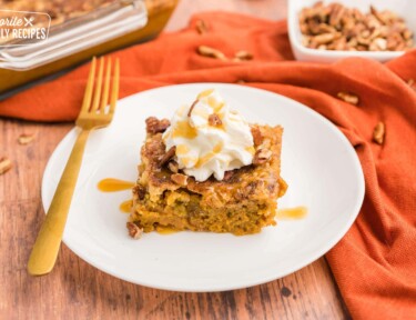 Pumpkin cobbler in a white plate with a gold fork.