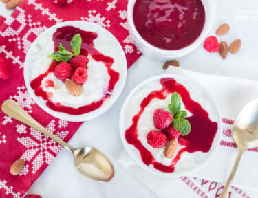 Two bowls of risalamande next to golden spoons