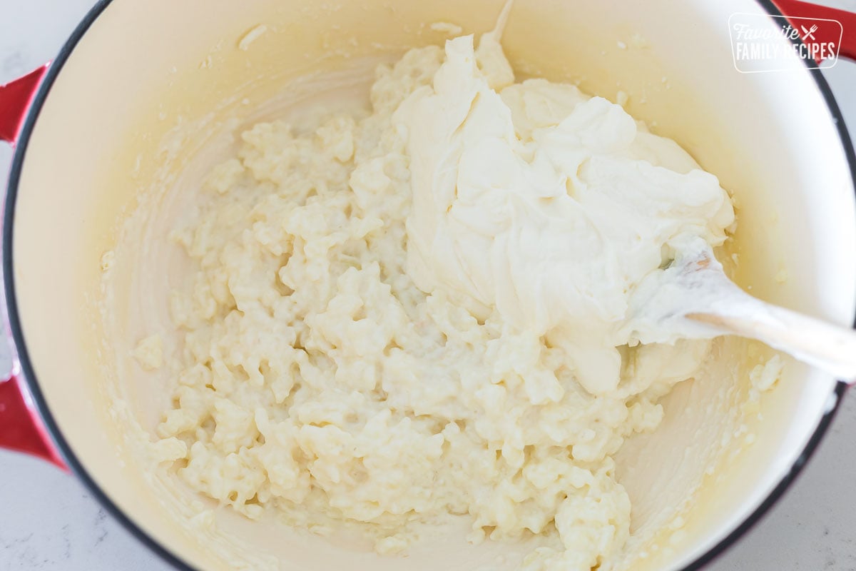 Whipped cream being folded into rice pudding to make risalamande