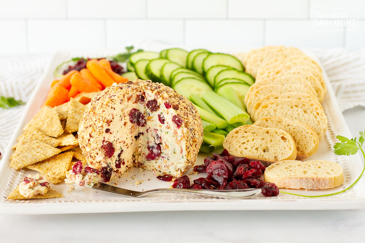 Full view of Cranberry Almond Bacon Cheese Ball board with vegetables, bread and crackers.