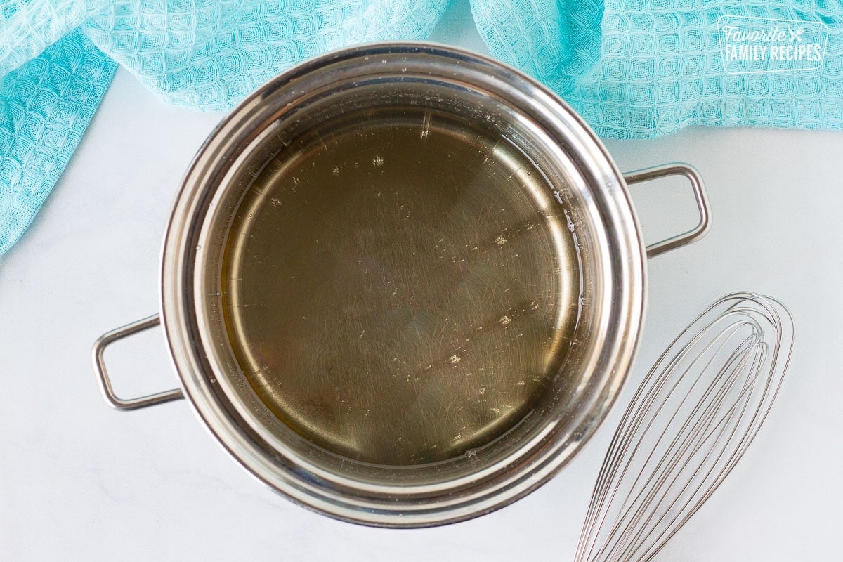 Pot of Sweet Coconut Bread glaze with whisk on the side.