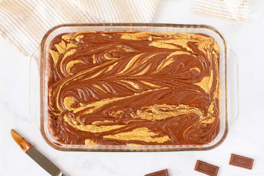 Glass dish with a Chocolate Peanut Butter Fudge swirl. Butter knife on the side.
