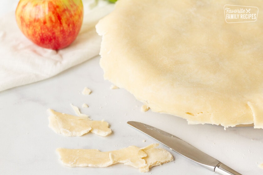 Butter knife cutting excess Apple Pie dough.