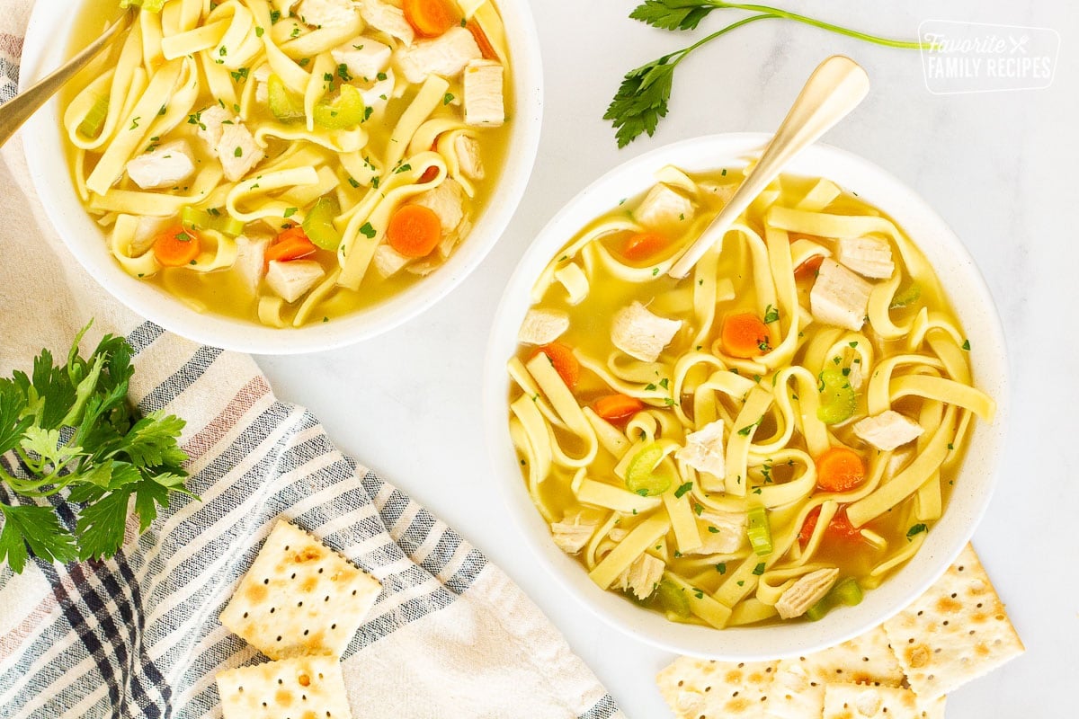 Two bowls of Homemade Chicken Noodle Soup with spoons.