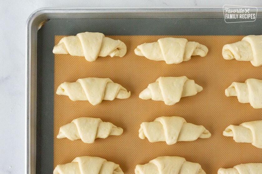 Baking sheet with silicone mat with unbaked Homemade Crescent Rolls.