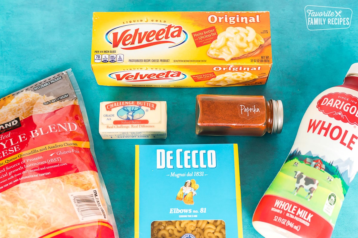 Ingredients to make Velveeta Mac and cheese including elbow macaroni, milk, cheese, and paprika