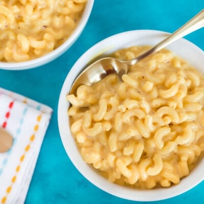 A close up of mac and cheese in a bowl with a spoon