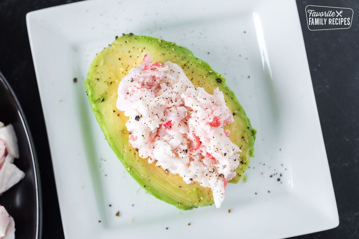 An avocado half stuffed with crab salad.