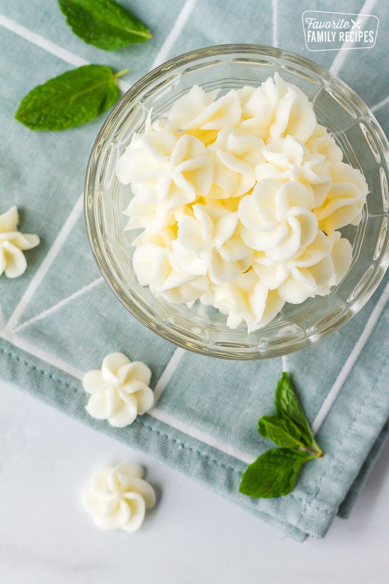 A glass bowl filled with white butter mints. 