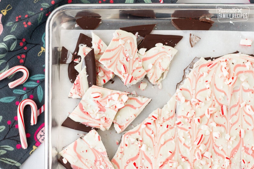 Breaking pieces of Peppermint Bark on a baking sheet.