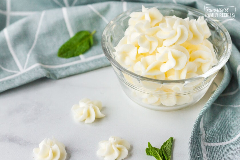 A side view of butter mints with cream cheese on a glass bowl.