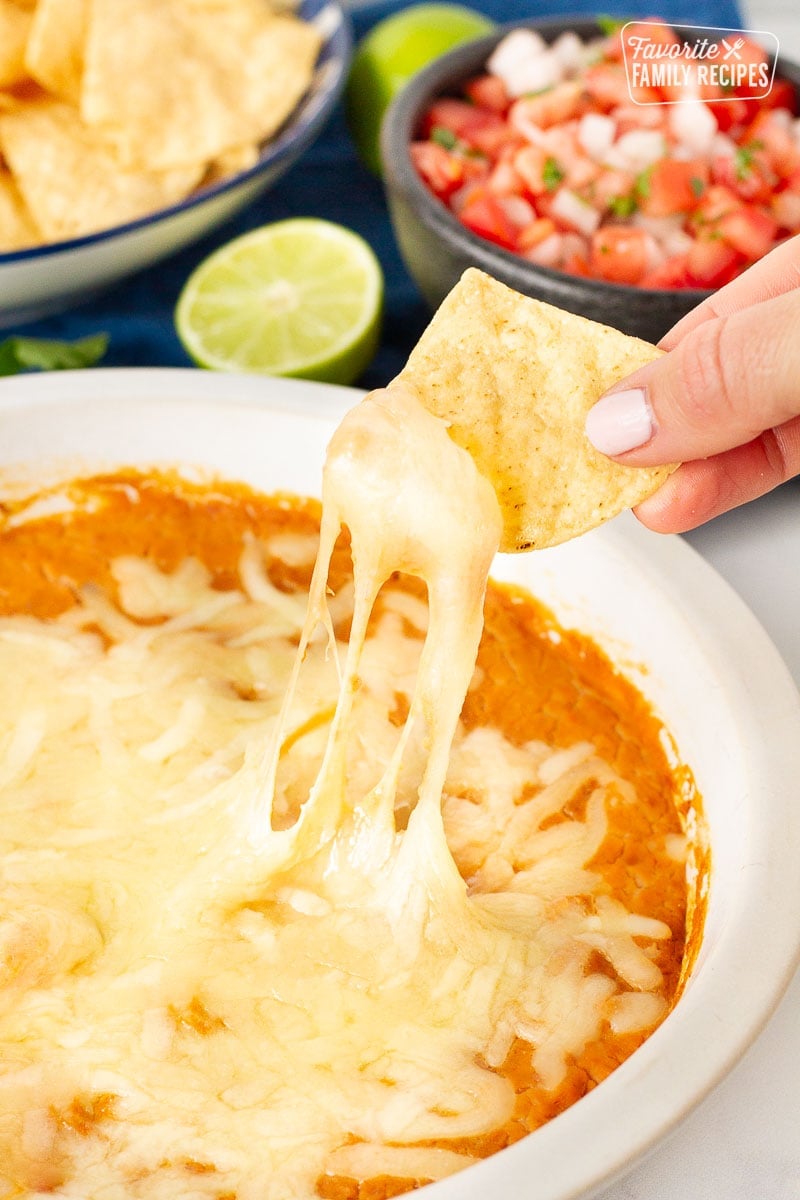 Chip scooping up Restaurant Style Refried Beans and melted cheese.