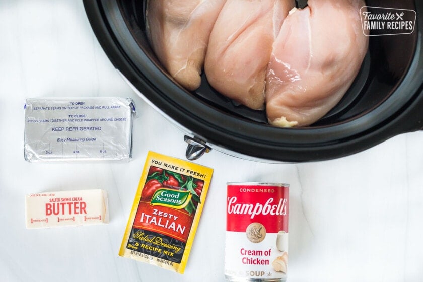 Ingredients to make Crockpot chicken Alfredo including Cream of Chicken soup, Zesty Italian Seasoning, butter, and cream cheese