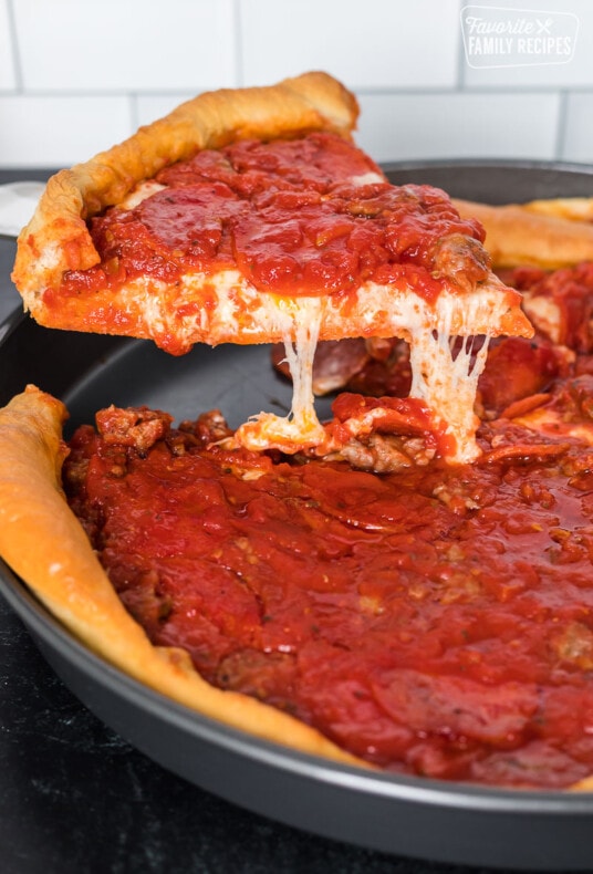 A Chicago-style deep dish pizza slice like Ginos East being pulled from a pan