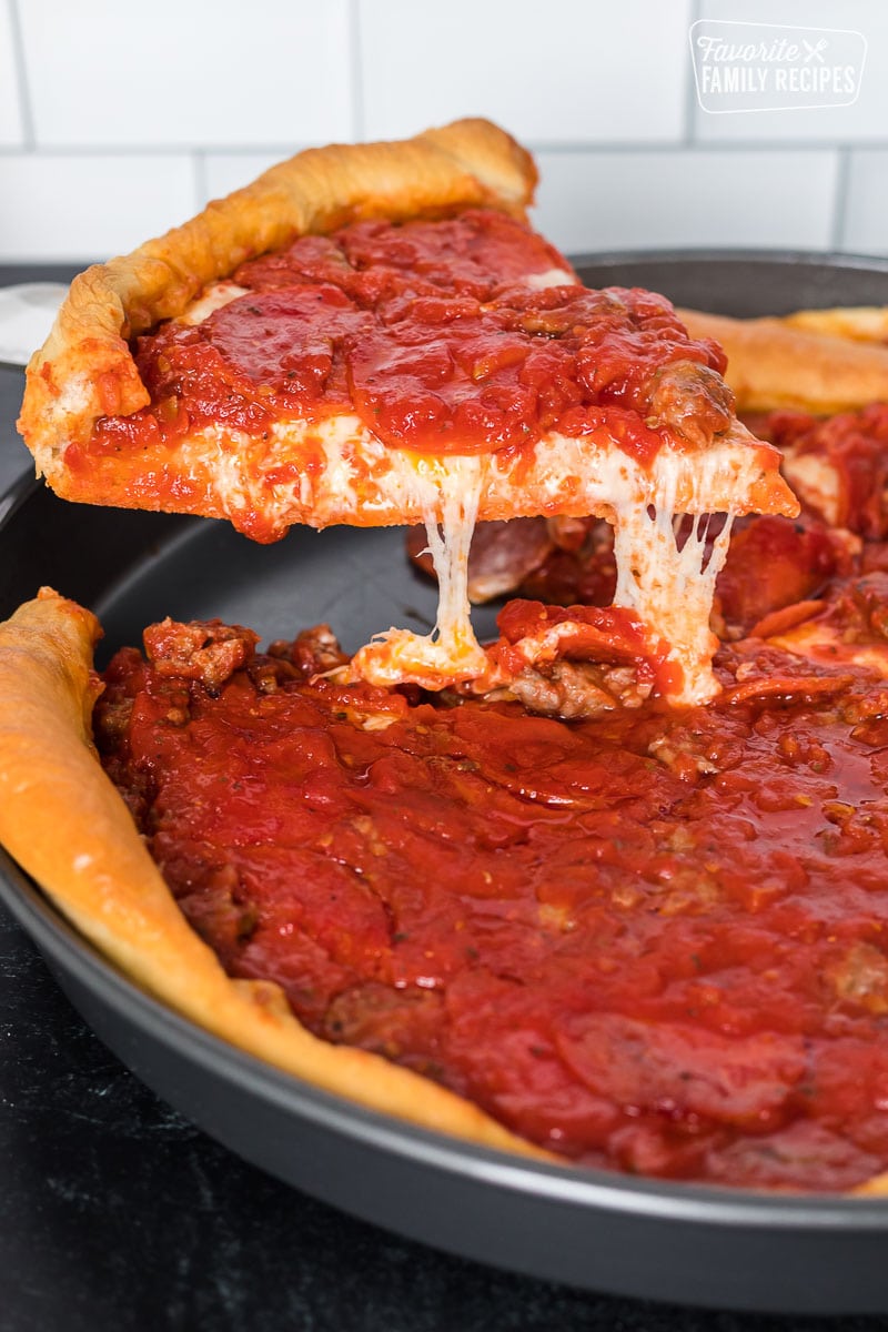 A Chicago-style deep dish pizza slice like Ginos East being pulled from a pan.