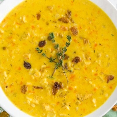 A bowl of mulligatawny soup topped with thyme