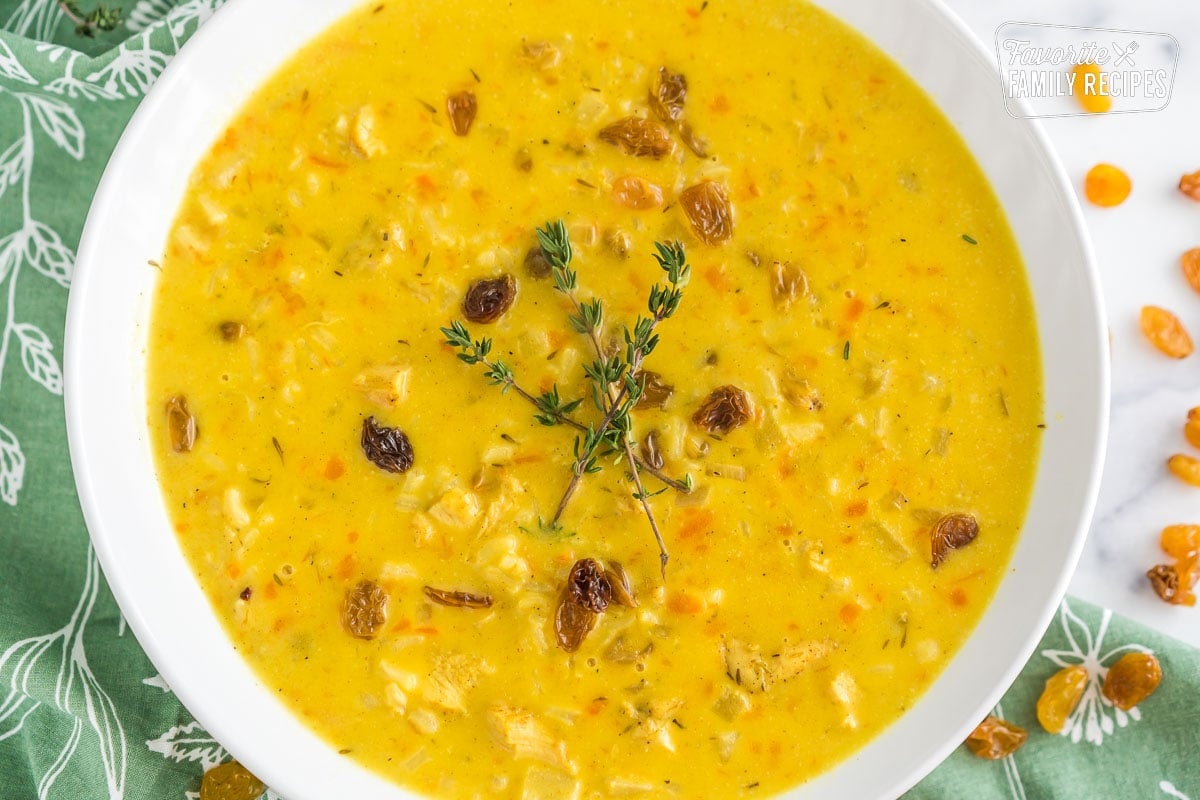 A bowl of mulligatawny soup topped with thyme