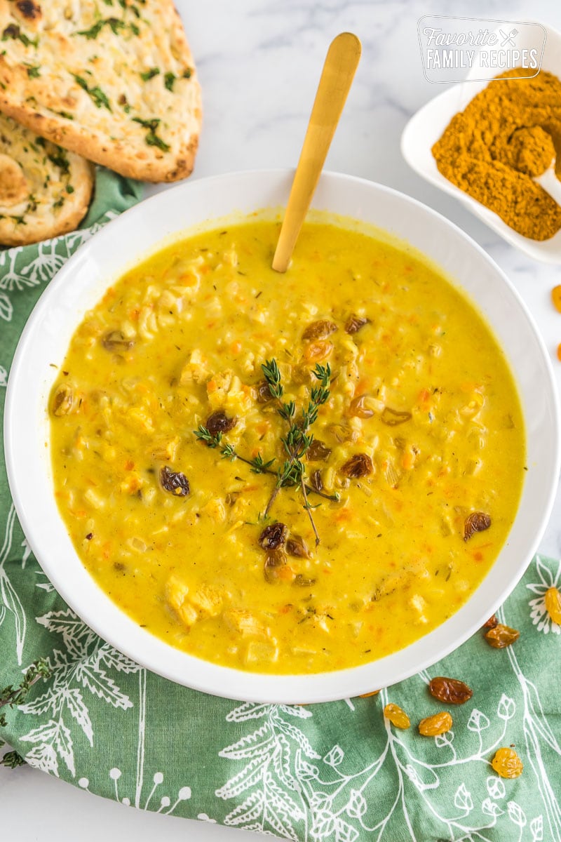 A bowl of mulligatawny soup topped with thyme.