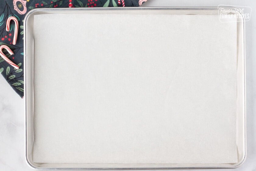 Baking sheet covered with parchment paper for Peppermint Bark.