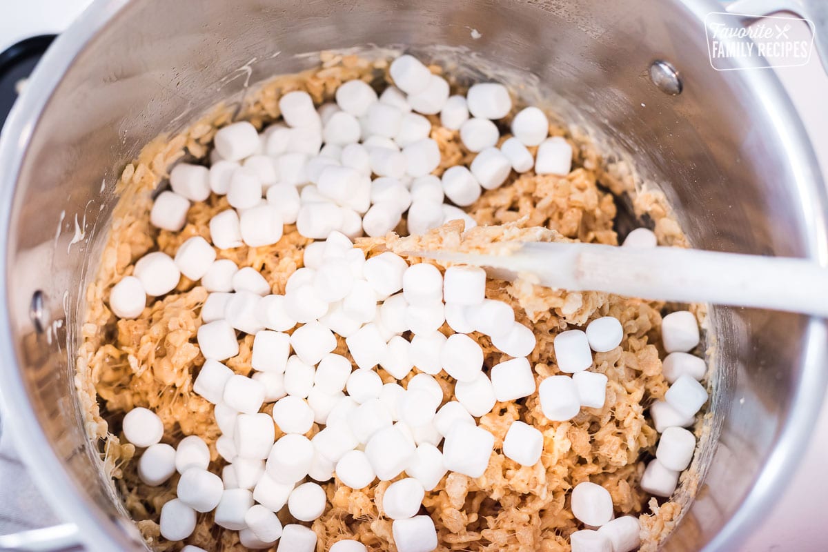 Mini marshmallows being stirred into a Rice Krispie mixture
