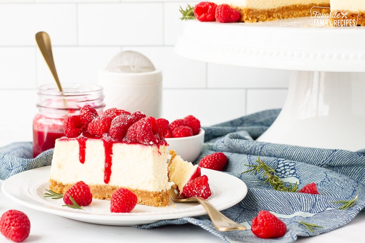 Raspberry Cheesecake on a plate with sauce dripping down the side.