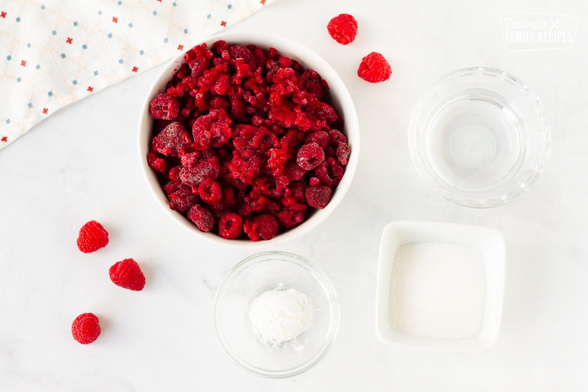 Bowl of frozen raspberries, sugar, water and corn starch to make raspberry coulis.